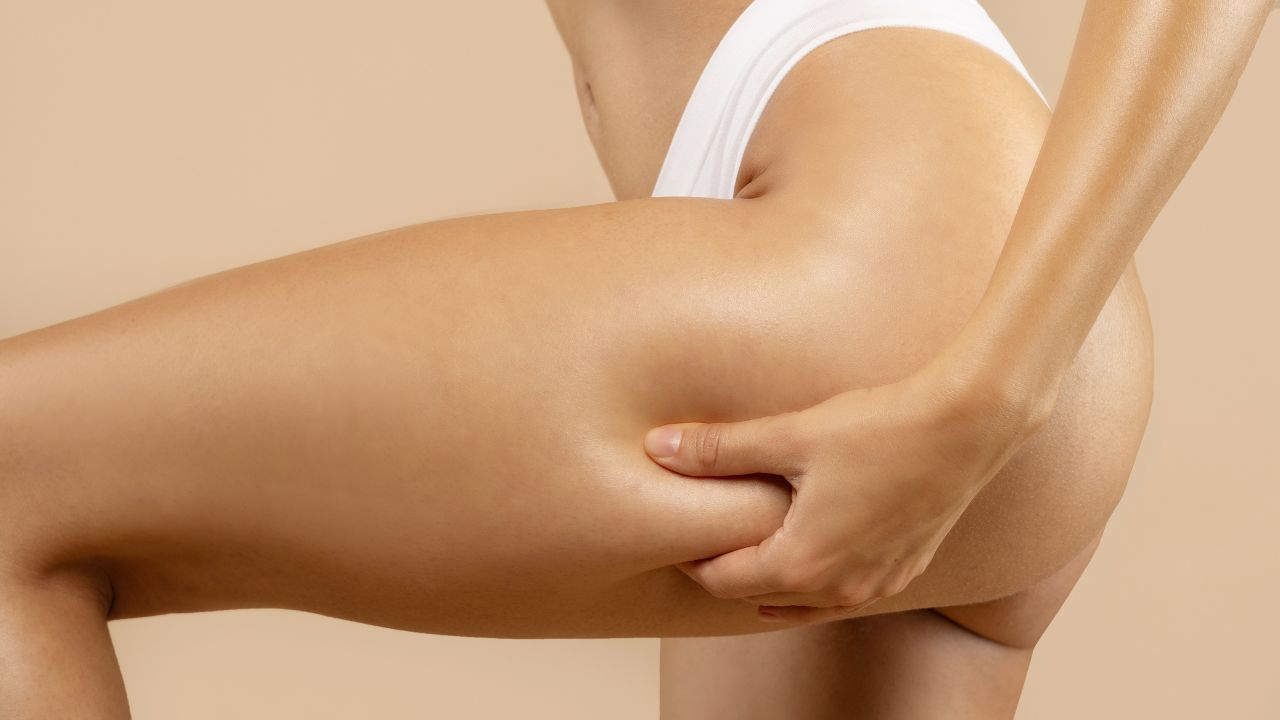 fit lady massaging pinching her thigh