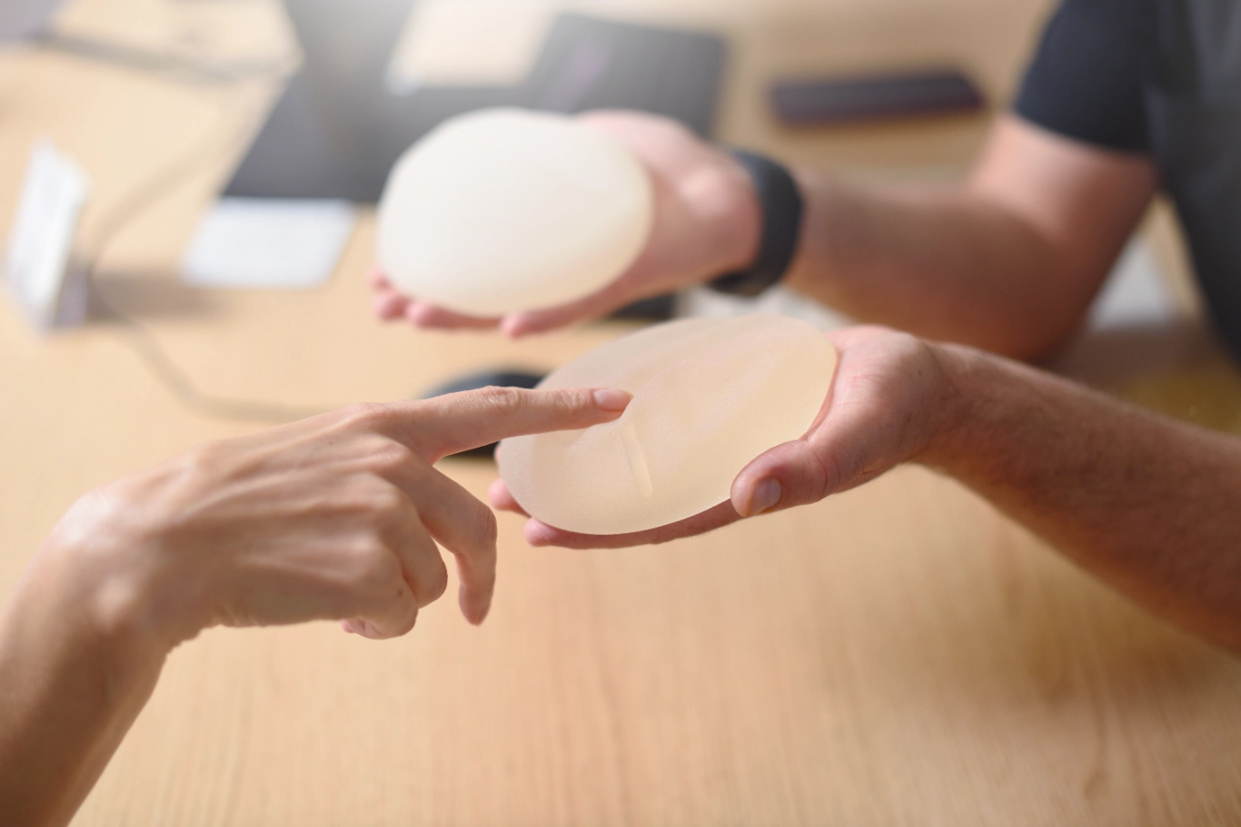 female plastic surgeon consultation Person examining silicone breast implants at consultation